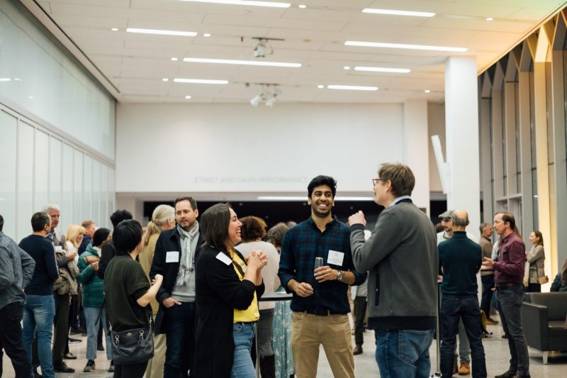 Many Virginia Tech faculty talk and socialize in the lobby of the Moss Arts Center at a faculty pop-up club.