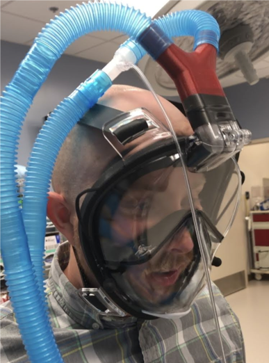 A person wears a scuba diving mask that has been adapted for potential use in COVID-19 treatment.