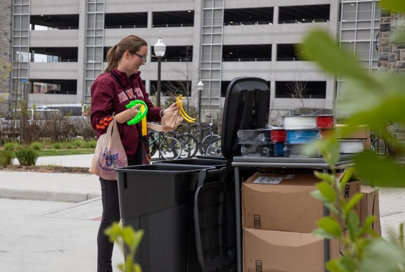 A person in a Virginia Tech jacket sorts headbands into different black bins.