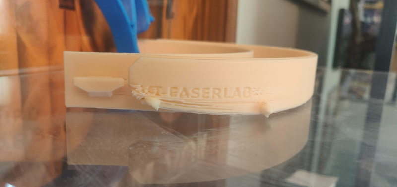 A peach-colored headband with a printing defect on the side. 